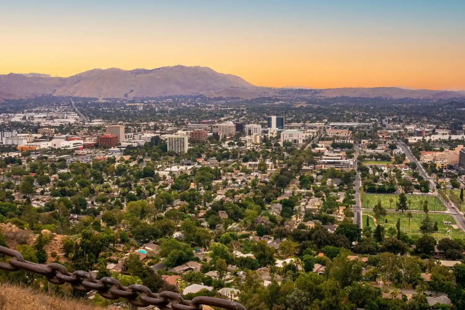 Aerial cityscape of downtown Riverside, California at golden hour with the Inland Empire skyline and Mission Inn district visible — symbolizing local market reach